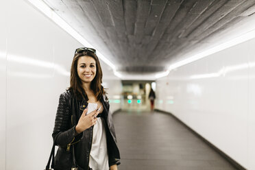 Porträt einer lächelnden jungen Frau in einem Tunnel - JRFF000625