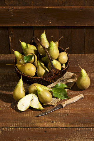 Wickerbasket of organic pears on wood stock photo