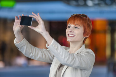 Smiling young woman taking a selfie - DIGF000400