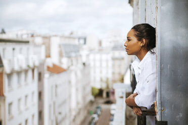 Frankreich, Paris, junge Frau auf dem Dachboden, die sich aus dem Fenster lehnt - ZEDF000106