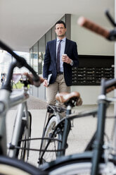 Businessman outdoors with coffee to go - MAUF000512