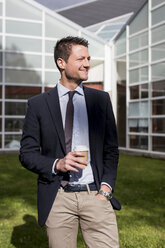 Smiling businessman outdoors with coffee to go - MAUF000513