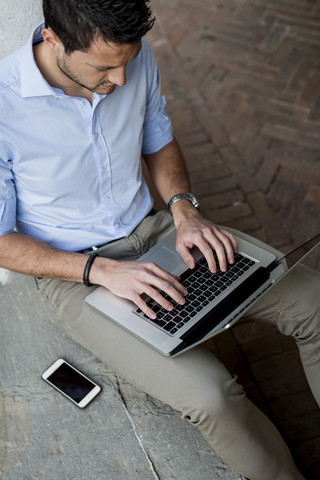 Geschäftsmann benutzt Laptop im Freien, lizenzfreies Stockfoto