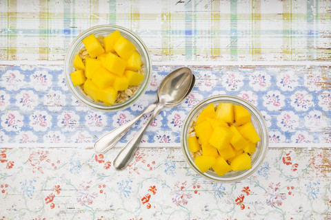 Zwei Gläser Overnight Oats mit gewürfelter Mango, lizenzfreies Stockfoto