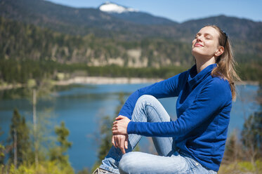 Germany, Bavaria, woman relaxing at lake Barmsee - DIGF000468