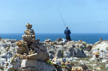 Portugal, Algarve, Sagres, cairn at coast, angler in the background - FRF000418