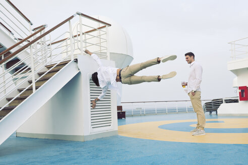 Zwei junge Männer tummeln sich auf einem Kreuzfahrtschiff und machen Gymnastik - SEF000904