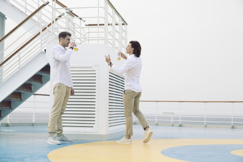 Zwei junge Männer trinken Bier auf einem Kreuzfahrtschiff, lizenzfreies Stockfoto