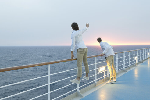 Junge Männer stehen an Deck eines Schiffes und beobachten den Sonnenuntergang - SEF000912