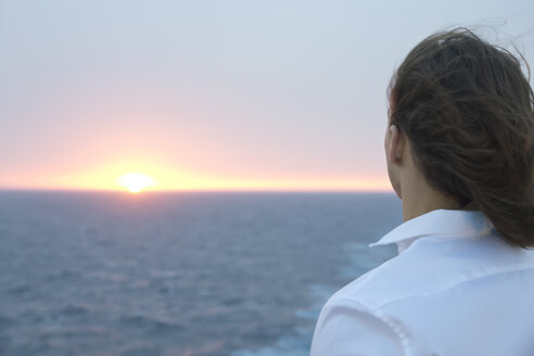 Junger Mann mit Blick auf den Sonnenuntergang über dem Meer - SEF000913