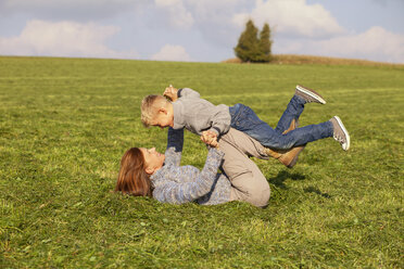 Carefree mother and son playing in meadow - MAEF011635