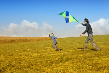 Father with son flying kite in meadow - MAEF011642