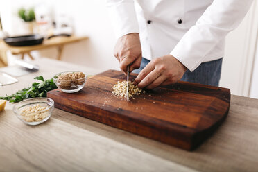 Chef preparing stuffing for ravioli, chopping nuts - JRFF000637