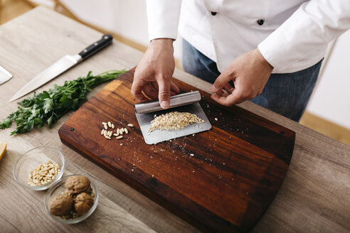 Chef preparing stuffing for ravioli, chopping nuts - JRFF000638