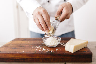 Koch bereitet Füllung für Ravioli vor, reibt Parmesankäse - JRFF000643