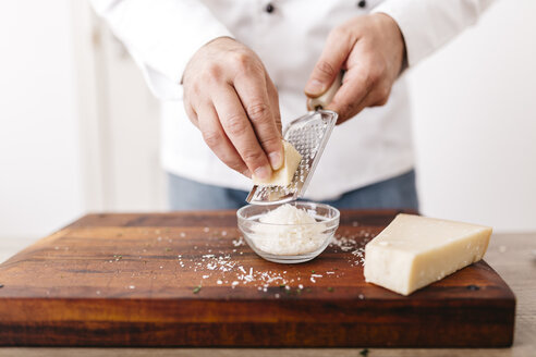 Chef preparing stuffing for ravioli, grating parmesan cheese - JRFF000643