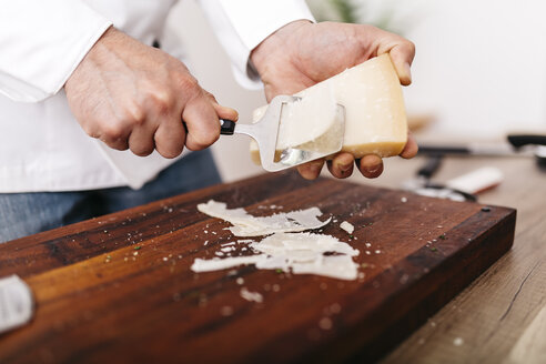 Chef preparing stuffing for ravioli, slicing parmesan cheese - JRFF000645