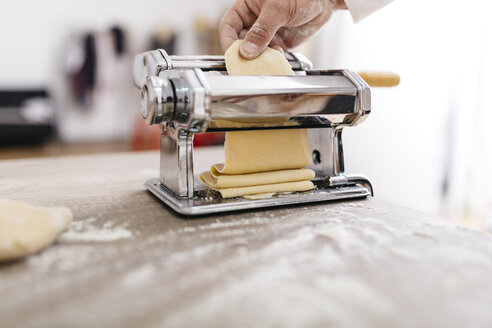 Koch rollt Teig mit Nudelmaschine - JRFF000655