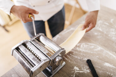 Chef rolling dough with pasta machine - JRFF000660