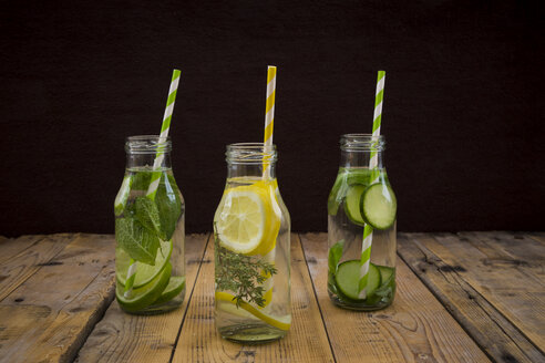 Drei Glasflaschen mit Tafelwasser, aromatisiert mit verschiedenen Früchten und Kräutern - LVF004857