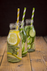 Three glass bottles of table water flavored with different fruits and herbs - LVF004858