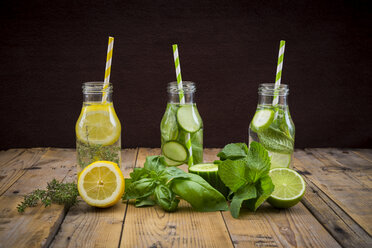 Drei Glasflaschen mit Tafelwasser, aromatisiert mit verschiedenen Früchten und Kräutern - LVF004862