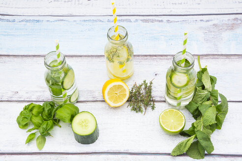 Drei Glasflaschen mit Tafelwasser, aromatisiert mit verschiedenen Früchten und Kräutern - LVF004863