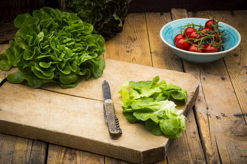 Vorbereitung von Salat, Tomaten, Salanova auf Schneidebrett, Messer - LVF004866