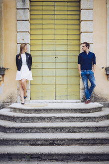 Italien, Verona, Paar steht neben Holztür und schaut sich an - GIOF001006
