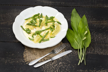 Ravioli filled with spinach and ricotta, green asparagus and sauce hollandaise on plate - MAEF011657