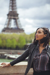 Frankreich, Paris, Junge Frau steht auf einer Brücke mit dem Eiffelturm im Hintergrund - ZEDF000114