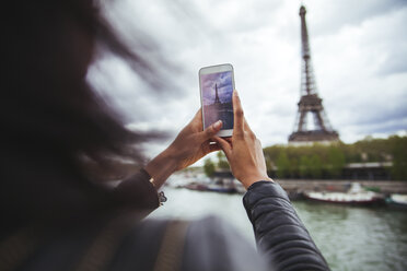Frankreich, Paris, Junge Frau nimmt Smartphone Foto des Eiffelturms - ZEDF000119