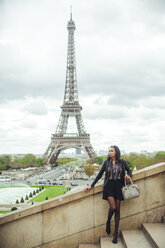 Frankreich, Paris, Junge Frau steht auf einer Brücke mit dem Eiffelturm im Hintergrund - ZEDF000121