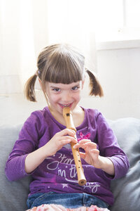 Little girl playing recorder at home - LVF004868