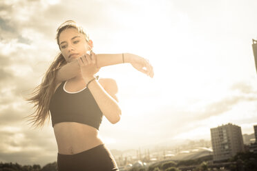 Athletic teenage girl stretching outdoors - SIPF000453