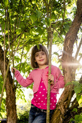 Porträt eines kleinen Mädchens, das auf einen Baum klettert - LVF004871