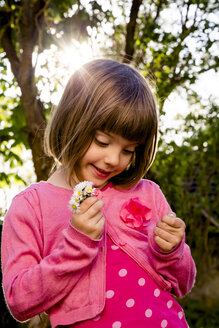 Portrait of little girl holding daisies in her hands - LVF004872