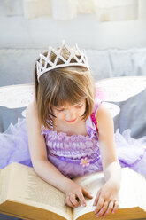 Kleines Mädchen, verkleidet als Feenkönigin, liest ein Buch - LVF004878