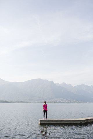 Italien, Lecco, junge Frau am See stehend, lizenzfreies Stockfoto