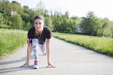 Young woman doing stretching exercises on path in the nature - MRAF000034