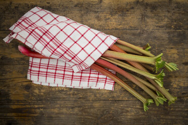 Rhubarb and kitchen towel on wood - LVF004881