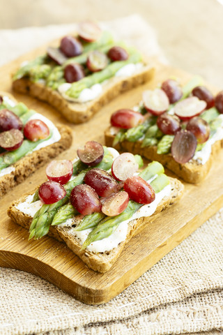 Spargel-Trauben-Toasts: Zutaten, Toastbrot, Sojaquark, Spargel, rote Weintrauben, schwarzer Pfeffer, lizenzfreies Stockfoto