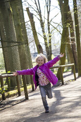 Happy little girl running with arms outstretched - JFEF000779