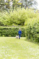 Back view of little girl walking with her dog in nature - JFEF000797