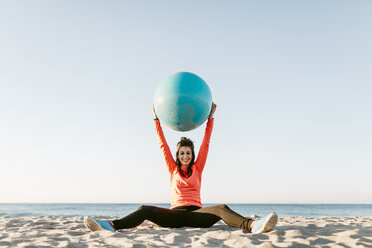 Frau beim Sport mit Gymnastikball früh am Morgen am Strand - JRFF000669