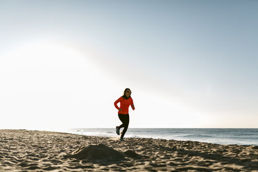 Woman jogging on the beach early in the morning - JRFF000675