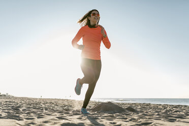 Woman jogging on the beach early in the morning - JRFF000677