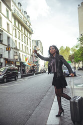 France, Paris, young woman hailing a taxi - ZEDF000124