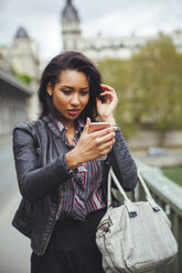 France, Paris, young woman looking at smartphone - ZEDF000129