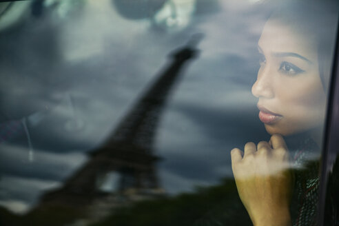 France, Paris, portrait of young woman watching Eiffel Tower through car window - ZEDF000133